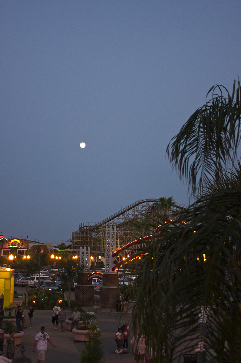 Full moon over the Kemah Boardwalk and the Boardwalk Bullet Roller Coaster