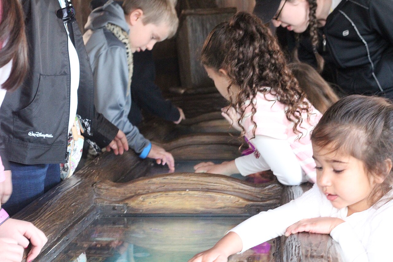 Kids at the gem table in the queue