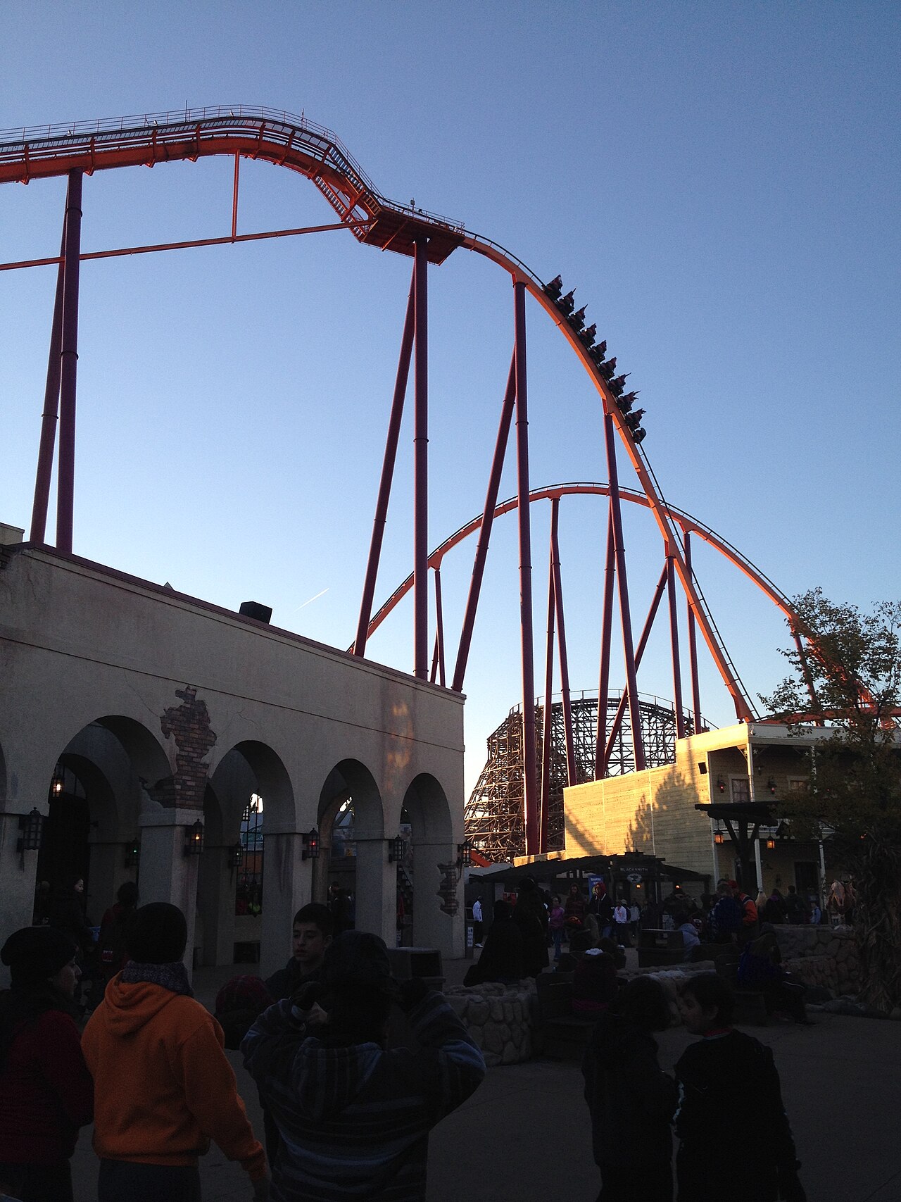 Raging Bull's orange track dropping from the top of its lift hill