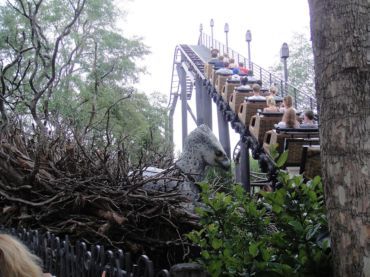 A train of wicker-basket cars climbing past Buckbeak on Flight of the Hippogriff